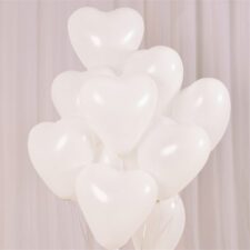 Cluster of white heart-shaped latex balloons in event setup