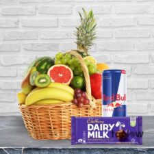 Luxury fruit hamper including pineapple, Cadbury Dairy Milk chocolate and an energy drink.