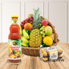 Large fruit basket with pineapple, grapes, a bottle of juice and packaged snacks.