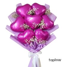 Magenta heart-shaped foil balloon bouquet with babyâ€™s breath and purple wrap