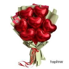 Bouquet of red heart-shaped foil balloons in pale green wrapping with ribbon