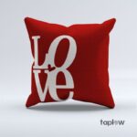 Red cushion with large white “LOVE” typography