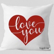 White cushion with large red heart and â€œlove youâ€ script