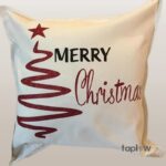 White cushion with â€œMerry Christmasâ€ and stylized tree graphic