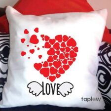 White cushion with red heart mosaic and “LOVE” text