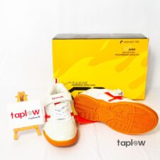 White sneakers with orange sole and yellow shoe box on white background (product shot).