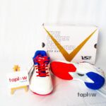 White sports shoes with multicolored sole and branded box (pair) product image.