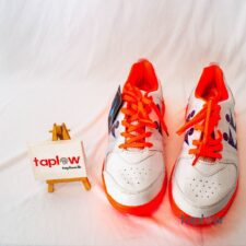 White and orange sports shoes with orange lace accents (pair) product photo.