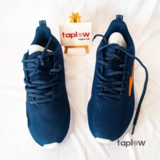 Pair of navy running shoes photographed on white background (product shot).