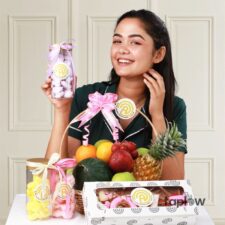 Assorted sweets and fruit gift set with jars and fruit and a young women