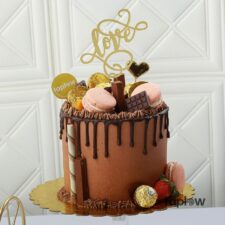 Chocolate drip cake topped with macarons and Ferrero Rocher with 'Love' cake topper (product image).